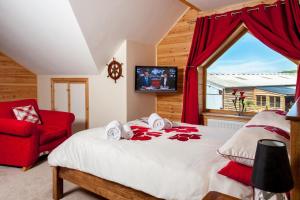 a bedroom with a large bed and a red chair at 9 Bed in Brecon oc-cvelo in Cray