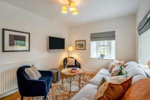 a living room with a couch and chairs and a tv at 4 Bed in Alyth oc-e31853 in Bridgend of Lintrathen