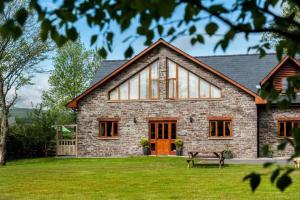 a large brick house with a bench in the yard at 9 Bed in Brecon oc-cvelo in Cray