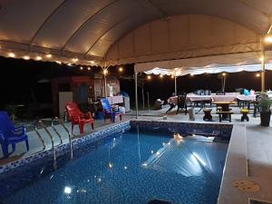 a swimming pool in a tent with chairs and a table at Villa Cempaka Homestay in Changlun +17 photos