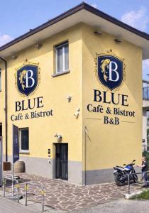 a yellow building with blue cats and babs signs on it at BLUE Airuno in Airuno
