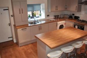 a kitchen with white cabinets and a wooden counter top at 103 Whalley Road Ramsbottom in Ramsbottom