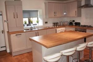 a kitchen with white cabinets and a wooden counter top at 103 Whalley Road Ramsbottom in Ramsbottom