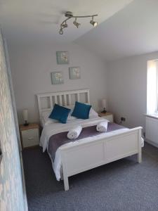a bedroom with a white bed with blue pillows at 103 Whalley Road Ramsbottom in Ramsbottom