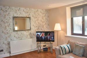 a living room with a tv and a couch at 103 Whalley Road Ramsbottom in Ramsbottom +44 photos