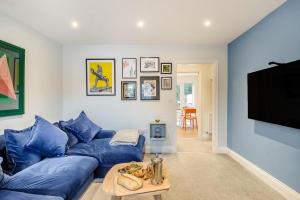 a living room with a blue couch and a tv at 3 Bed in Framlingham oc-m32532 in Framlingham