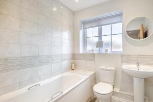 a bathroom with a tub and a toilet and a sink at 3 Bed in Framlingham oc-m32532 in Framlingham +8 photos