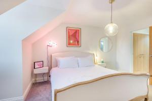 a bedroom with a white bed and a mirror at 3 Bed in Framlingham oc-m32532 in Framlingham