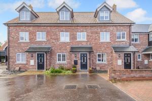 a large brick house with black doors and windows at 3 Bed in Framlingham oc-m32532 in Framlingham