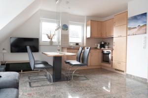 a kitchen with a table and chairs in a room at Haus-Eriel-OG-rechts in Brösum