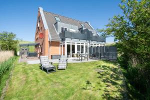 a house with a yard with chairs and a table at Haus-Eriel-OG-rechts in Brösum
