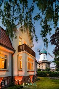 a house with a windmill in the background at Villa Hygge Kappeln - Design Ferienwohnungen in Kappeln