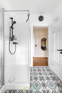 a bathroom with a shower and a tile floor at Villa Hygge Kappeln - Design Ferienwohnungen in Kappeln +21 photos
