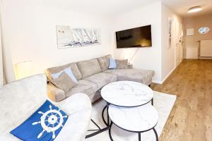 a living room with a couch and two tables at Achtern Diek Haus 12d Wohnung 1 PALSTEK in Müggenburg