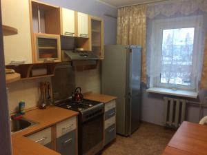 チャイコフスキーにあるApartments Vizitの小さなキッチン(冷蔵庫付)、窓が備わります。