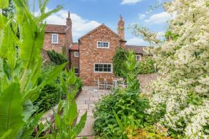 an exterior view of a house with trees and flowers at 3 Bed in Crayke oc-y056 in Crayke