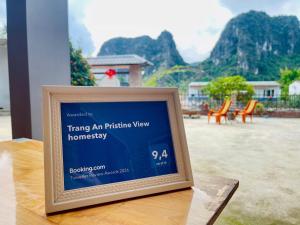 a sign sitting on top of a table with a view of a mountain at Trang An Pristine View Homestay in Ninh Binh