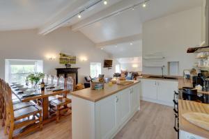 a large kitchen with white cabinets and a table at 5 Bed in Muker oc-ds1056 in Muker