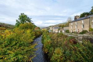 a river in a small village with buildings at 5 Bed in Muker oc-ds1056 in Muker