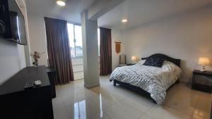 a bedroom with a bed and a large window at Apartamento moderno y comodo in Cochabamba