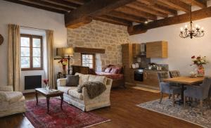 a living room with a couch and a table at Domaine Le Verger Kleinschalige B&B met groot zwembad en buitenkeuken in Saint-Estèphe