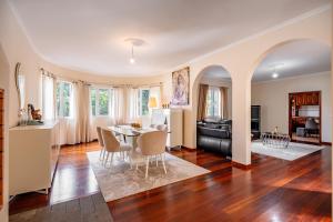 a dining room and living room with a table and chairs at The Orange House, By OP in Boaventura