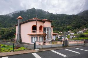 a pink building with a mountain in the background at The Orange House, By OP in Boaventura