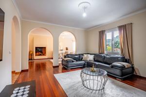 a living room with a leather couch and a table at The Orange House, By OP in Boaventura
