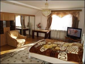 a bedroom with a large bed and a living room at Apartament Sanitarna 17 in Lviv