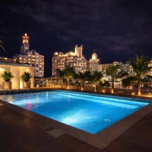 a large swimming pool with a city skyline at night at Dolce by Wyndham Miami Beach in Miami Beach
