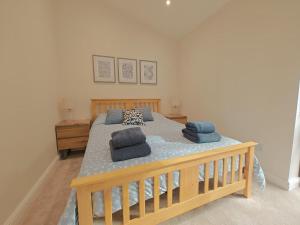 a bedroom with a wooden bed with blue pillows at 2 Bed in Stanton oc-p30248 in Ticknall