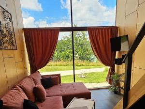 a living room with a couch in front of a large window at Tiny House 2 Dedinky Privat Wellness in Dedinky