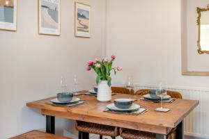 a wooden table with a vase of flowers on it at 2 Bed in Mumbles oc-v30980 in The Mumbles +18 photos