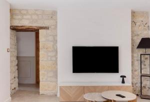 a living room with a tv on a wall at La Maison Léoncine in Allonnes +17 photos