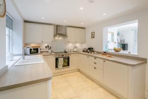a kitchen with white cabinets and a large window at 3 Bed in Beer oc-d32358 in Beer