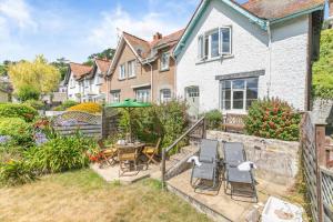 a garden with a table and chairs in front of a house at 3 Bed in Beer oc-d32358 in Beer