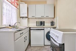 a white kitchen with a sink and a dishwasher at Host & Stay - Dover Retreat in Ipswich