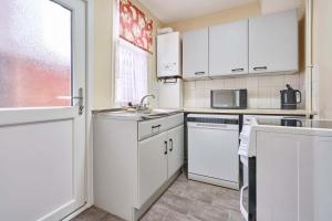 a kitchen with white cabinets and a sink and a window at Host & Stay - Dover Retreat in Ipswich