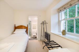 a white bedroom with a bed and a window at 5 Bed in Ulpha oc-b32731 in Ulpha