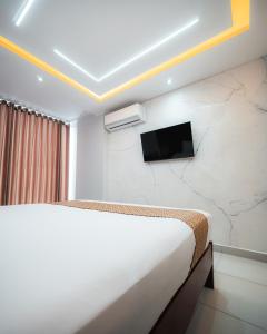 a bedroom with a bed and a tv on a wall at Hotel Nilas in Tarapoto