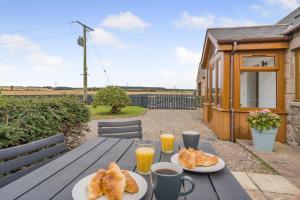 a wooden table with two plates of bread and orange juice at 2 Bed in Hatton oc-t32765 in Peterhead