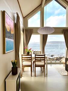 a dining room with a table and chairs and the ocean at Steigen Cabin North in Steigen
