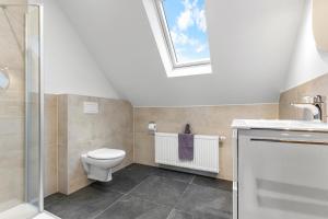 a bathroom with a toilet and a sink and a window at Watt'n Mehr in Krummhörn +23 photos