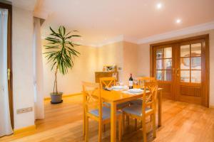 a dining room with a table and chairs and a plant at Apartamentos Gasteiz in Vitoria-Gasteiz