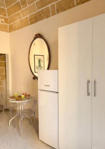 a kitchen with a white refrigerator and a table at Gallipoli - Suite Levante in Gallipoli