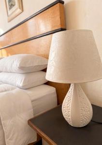 a white lamp on a table next to a bed at Gallipoli - Suite Levante in Gallipoli