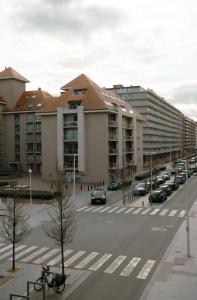 a parking lot with parked cars in a city at The White coast studio in Nieuwpoort