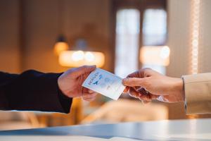 a man handing another man a piece of paper at Nomada House by SH Hoteles in Denia