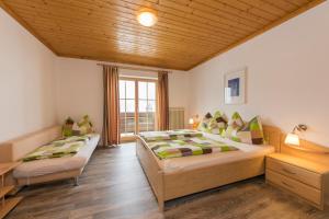 a bedroom with two beds and a window at Hinterbichlhof - Apartments in Viehhofen