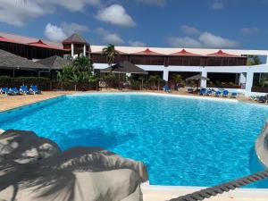 a large swimming pool in front of a resort at La Casa Manao - Charmant Studio SF in Saint-François +6 photos